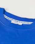 Close-up of a blue shirt with a white label on a light gray background